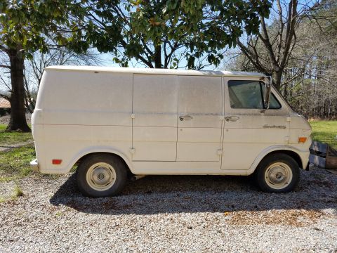 1971 Ford Ranchero - A dusty white panel van is parked outdoors on a gravel surface under a tree.