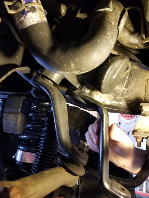1996 Ford Bronco - Underside view of a vehicle's suspension system, focusing on the steering linkage and a coil spring.