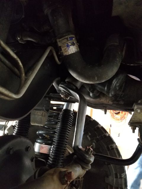1996 Ford Bronco - Close-up of the underside of a vehicle, focusing on suspension and steering parts.