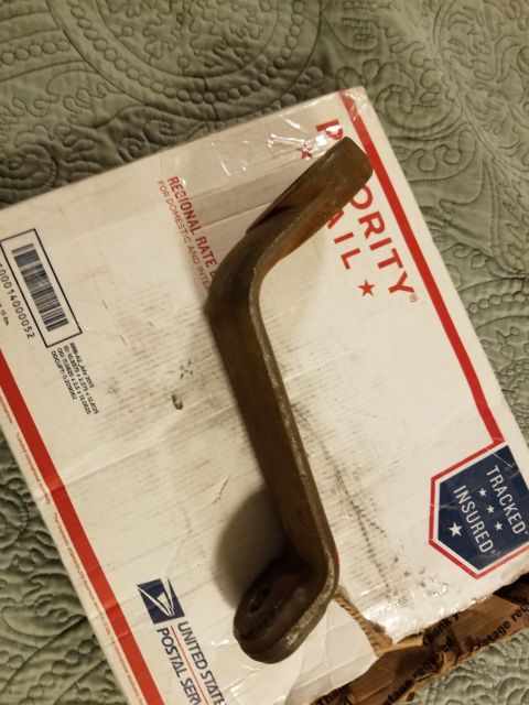 1996 Ford Bronco - A metal steering component, possibly a pitman arm, rests on a USPS Priority Mail box.