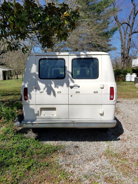 1971 Ford Ranchero - This white Ford Econoline van is seen from the rear, parked in a grassy, outdoor area.