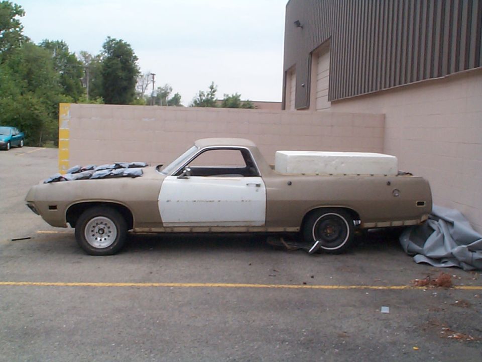 Tan and white 1971 Ford Ranchero side view, hood covered with tarps