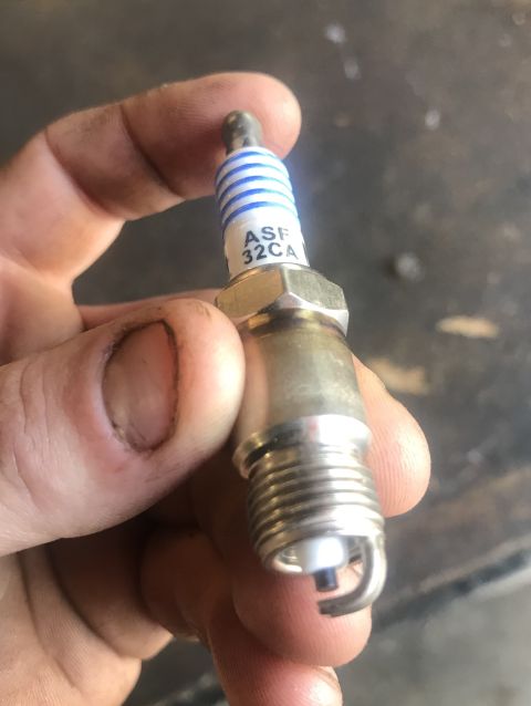 1995 Ford Bronco - A spark plug with visible text is held in a hand.