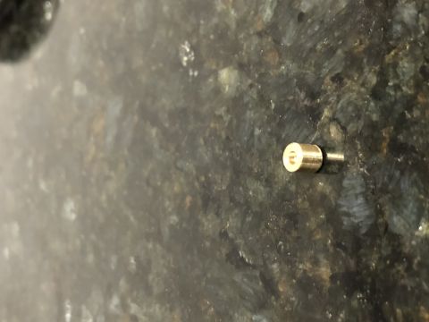1983 Yamaha Venture - A single brass carburetor jet is shown against a dark, speckled background. The Supermotors.net logo is in the lower right corner.