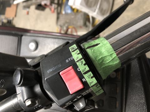 1983 Yamaha Venture - Close-up of motorcycle handlebar controls, an engine stop switch and handwritten markings on green tape.
