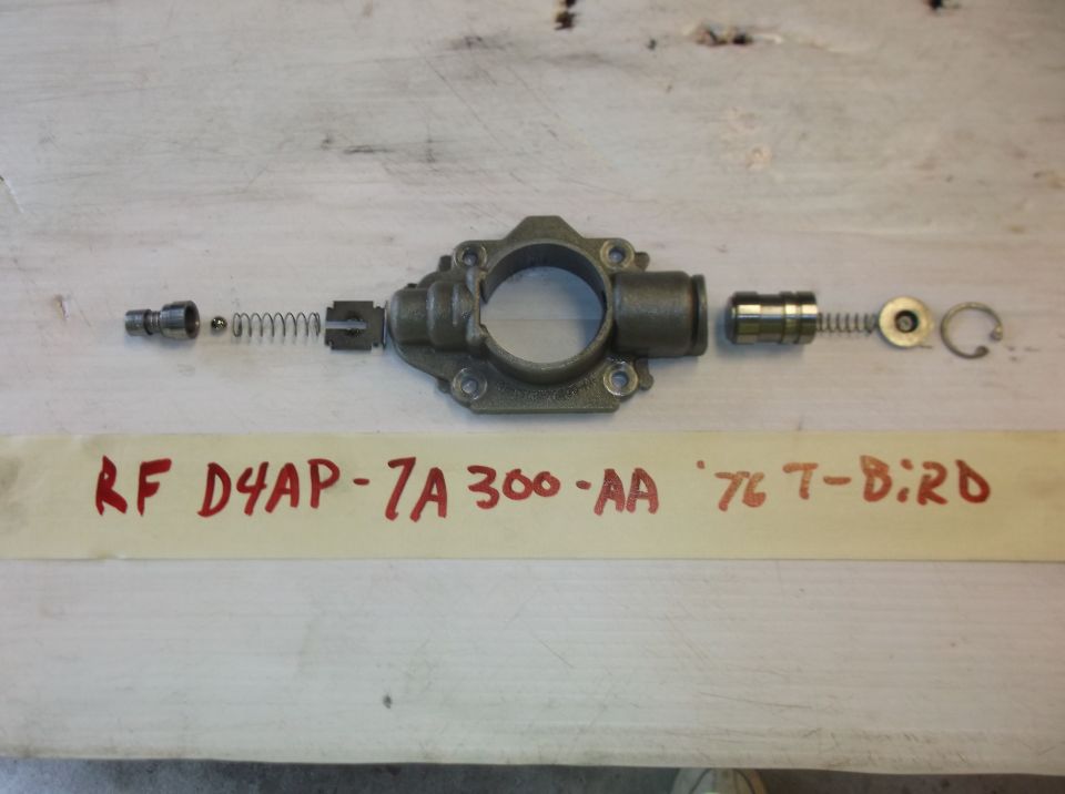 Disassembled oil pump with springs, ball, and plunger. Paper shows 'RF D4AP-7A 300-AA '76 T-BIRD'