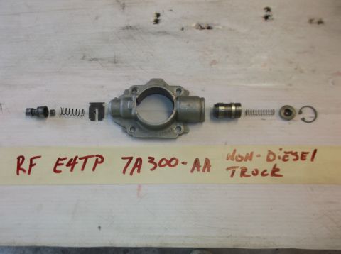 1979 Ford Ranchero - Various parts of a brake master cylinder are arranged on a workbench with identifying text written on tape.