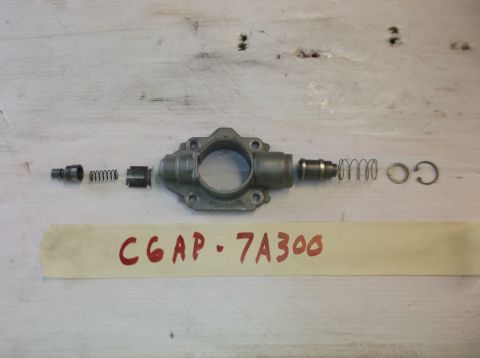 1979 Ford Ranchero - Disassembled oil pump components, including springs and a retaining clip, are laid out on a wooden surface with a label reading CGAP-7A300.
