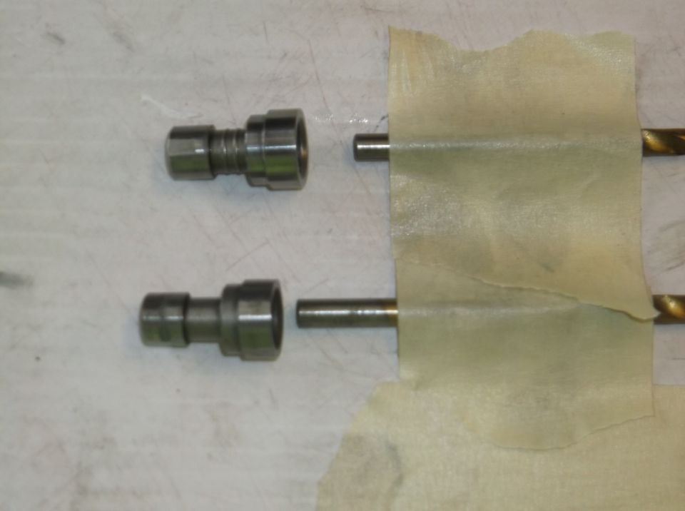 two metal valve components and rods taped together