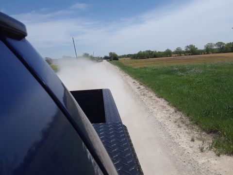 1994 Ford Bronco - Driving down a dusty dirt road, kicking up dust from the rear of the truck.