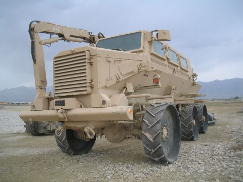 1981 Ford Bronco - This heavy-duty military truck features a crane arm and a unique six-wheel drive system, seen in a desert landscape.