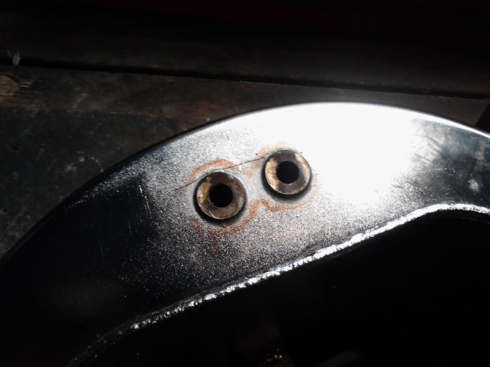 Motorcycle frame section with two bolt holes and visible crack near one hole
