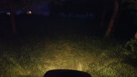 2007 Subaru Impreza - The headlights of a vehicle illuminate a dark yard at night, with a house and trees visible in the distance.