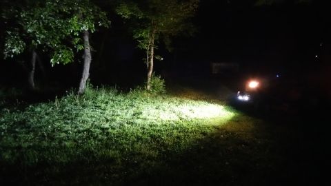 2007 Subaru Impreza - Headlights cut through the darkness, lighting up a grassy area with trees.