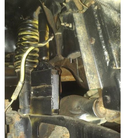 1992 Ford Bronco - Undercarriage view shows suspension parts like a shock and spring, with visible rust and wear.