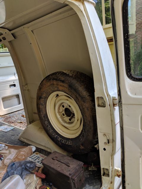 1971 Ford Ranchero - The interior of a van shows a spare tire and various items on the floor.