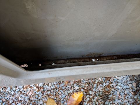 1971 Ford Ranchero - The lower edge of a vehicle door shows signs of rust and corrosion, with holes visible in the metal.