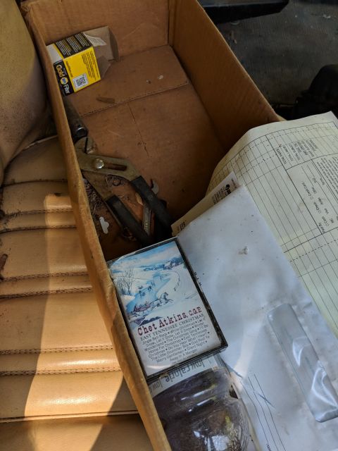 1971 Ford Ranchero - Box of items including tools and a Chet Atkins cassette tape sits on a car seat.