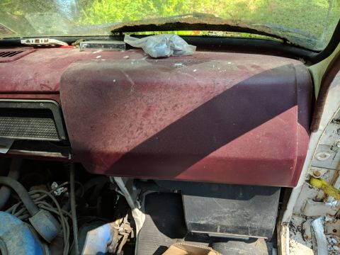 1971 Ford Ranchero - The interior of an old vehicle shows a dusty dashboard and exposed engine components.