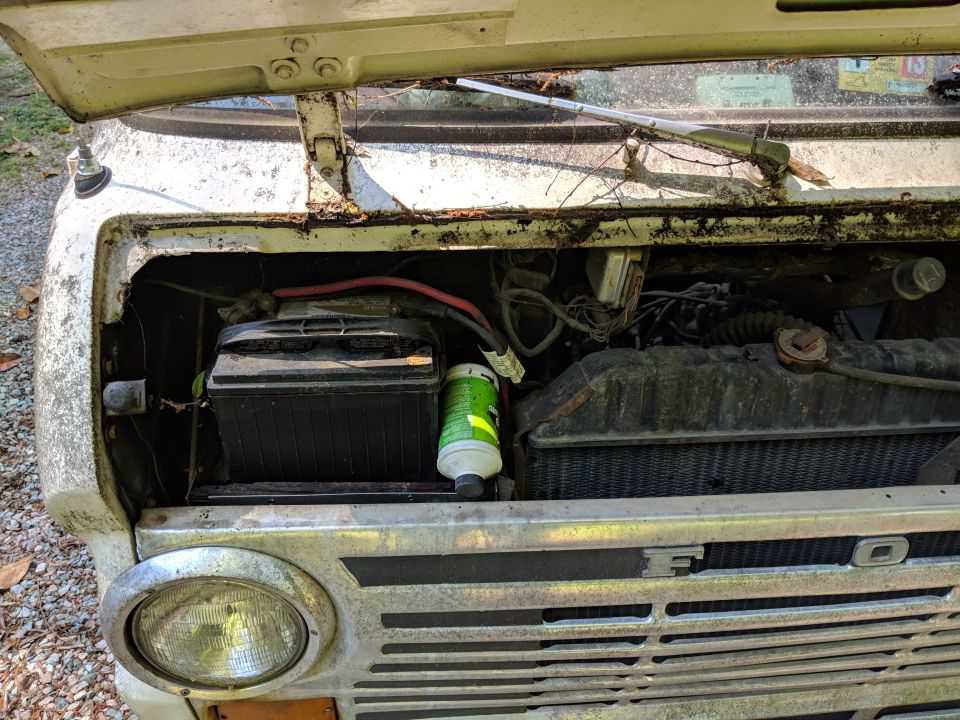 White 1971 Ford Ranchero engine bay with battery, radiator, and grille visible