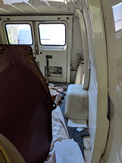 1971 Ford Ranchero - View of the interior of a white van, looking towards the rear doors. Another white vehicle is visible through the windows.