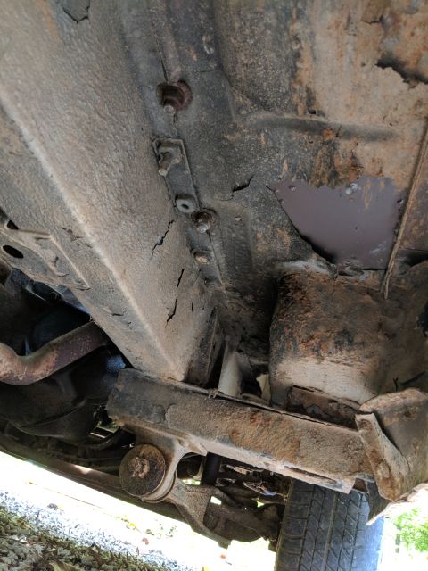 1971 Ford Ranchero - The underside of a vehicle displays significant rust and structural compromise.