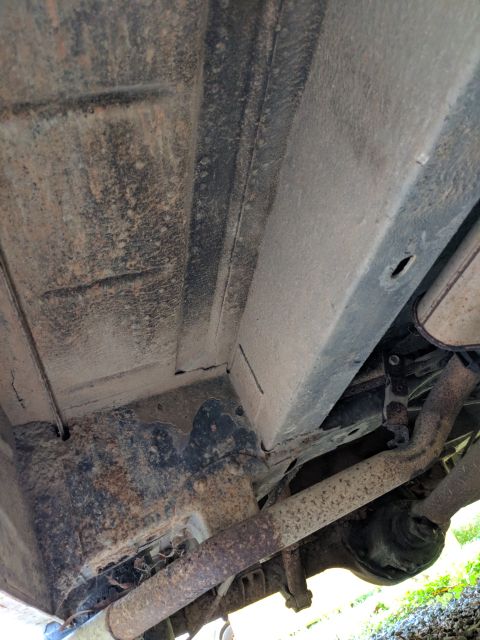 1971 Ford Ranchero - Underside view of vehicle frame and exhaust system, showing rust and wear.