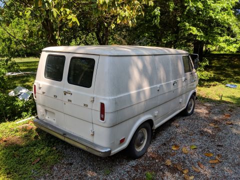 1971 Ford Ranchero - This 1971 Ford Econoline van is parked outdoors on a gravel driveway with trees in the background.