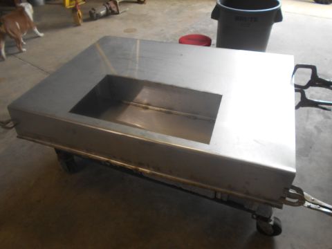 1992 Ford Bronco - This metal fabrication is mounted on wheels and has a rectangular opening in its surface. A dog is visible in the background.