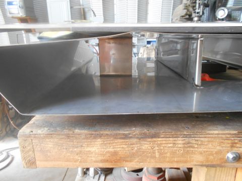 1992 Ford Bronco - A shiny metal component rests on a wooden workbench, reflecting the surrounding environment.
