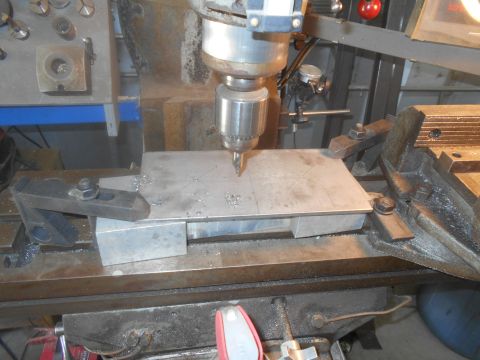 1992 Ford Bronco - A milling machine is used to drill a metal plate, with metal shavings scattered around the workpiece.