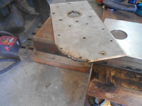 1992 Ford Bronco - A metal plate with a central hole and numerous smaller holes is shown, supported by wooden blocks.