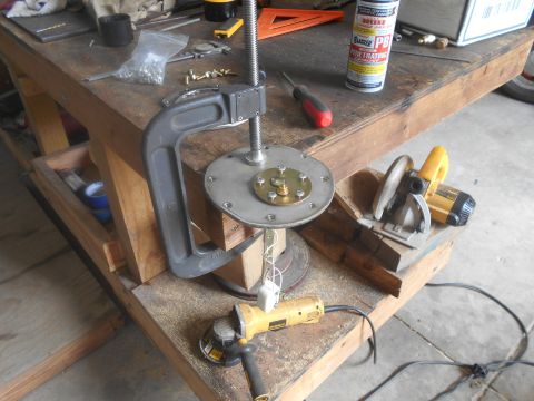 1992 Ford Bronco - A fuel pump assembly is clamped to a workbench, surrounded by tools including an angle grinder and a circular saw.