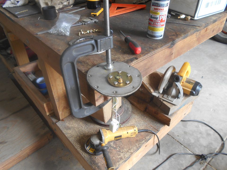 Fuel pump assembly clamped to workbench with angle grinder and circular saw