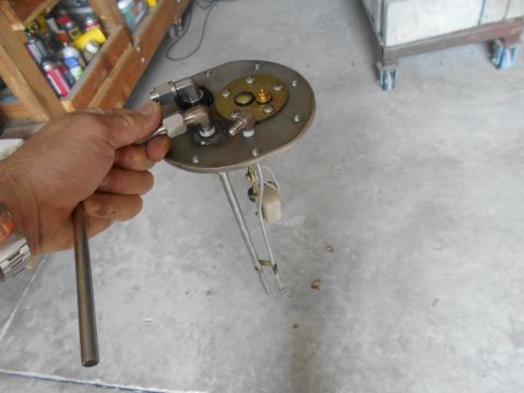 1992 Ford Bronco - A person holds a fuel sending unit, a component used to measure fuel level in a tank.
