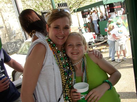 1995 Ford Bronco - Two women celebrate at a parade, adorned with colorful beads.