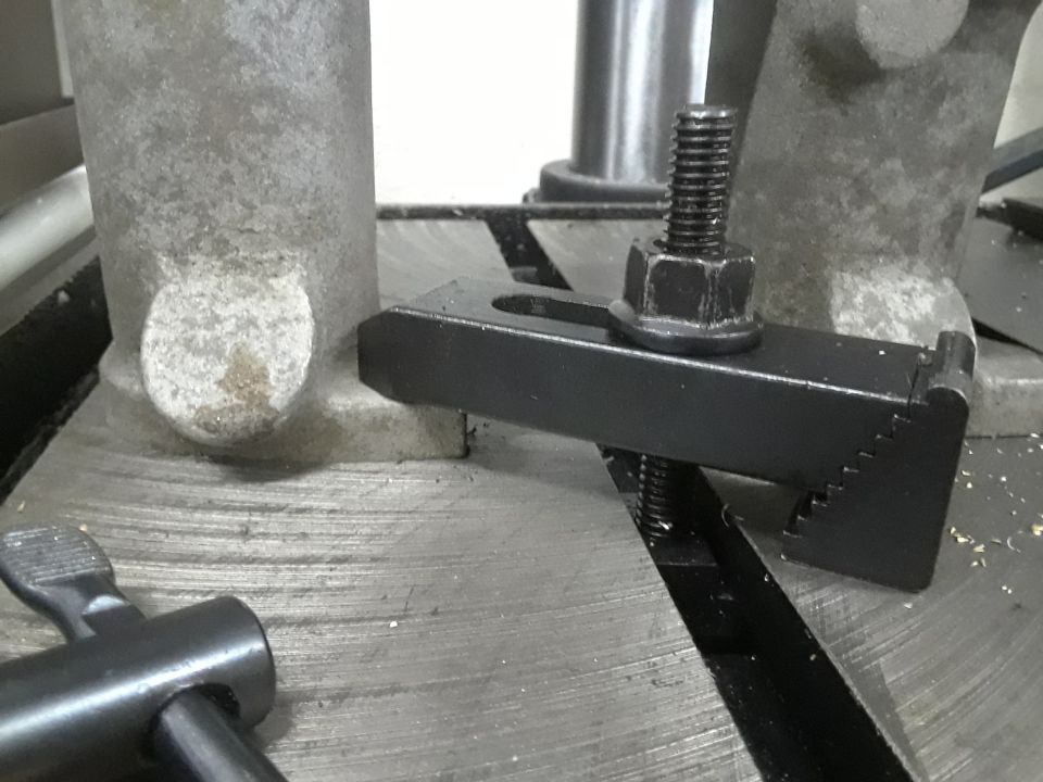 T-slot clamp with a bolt and nut securing it to a machine table