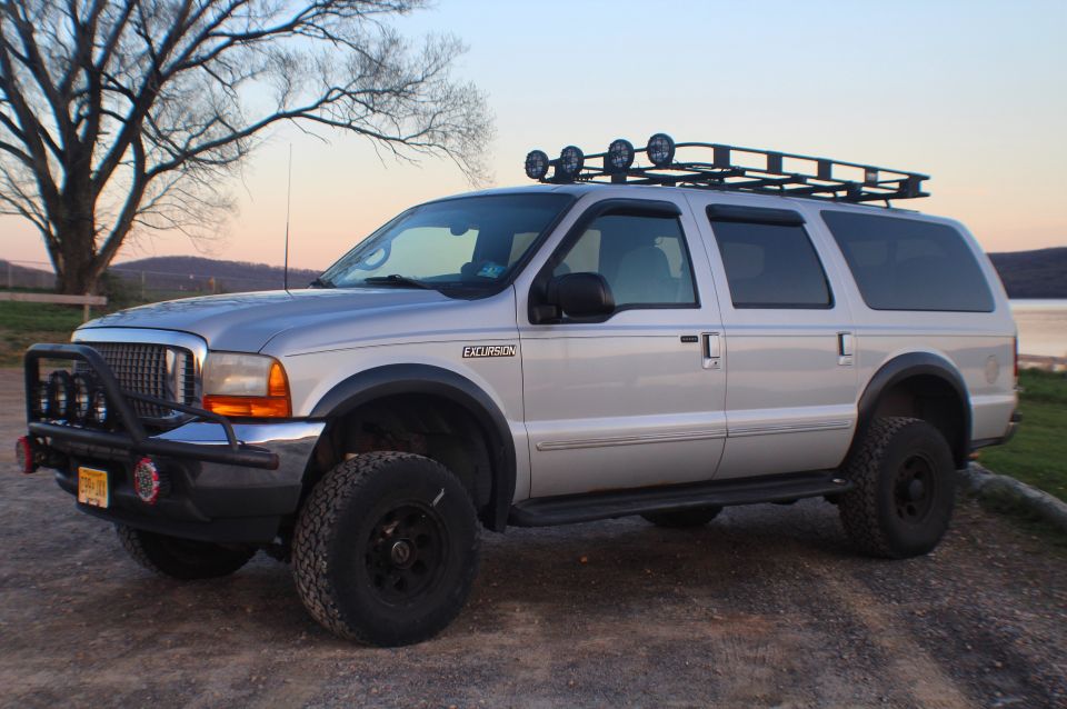 Silver 2000 Ford Excursion with roof rack and brush guard