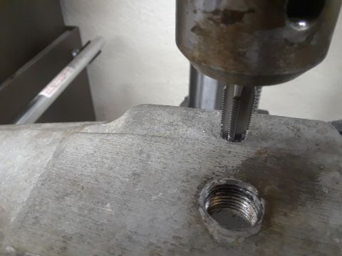 1985 Ford Bronco - A tap is used to create threads in a metal component, likely for a repair or assembly.