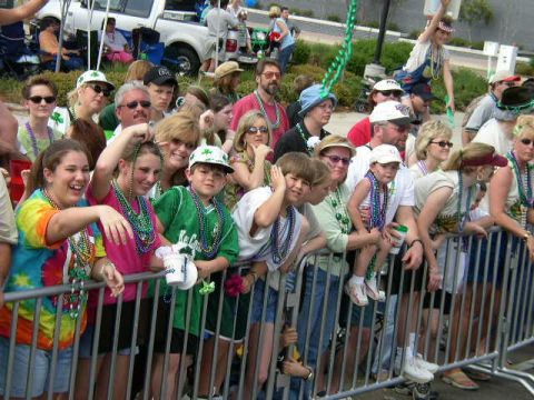 1995 Ford Bronco - Spectators line a fence, many adorned with colorful beads, as they watch an event.