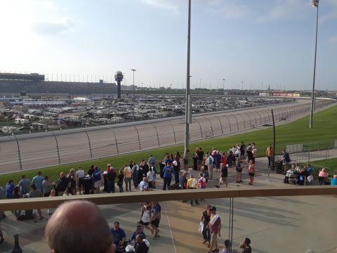 1994 Ford Bronco - A wide view of a race track, showing RVs parked in the distance and crowds of people milling about near the track's edge.