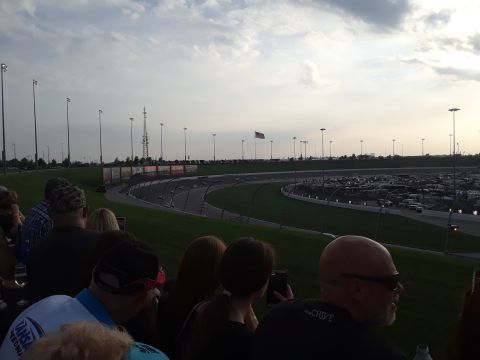 1994 Ford Bronco - Spectators watch a race from the stands overlooking the track and a large parking area.