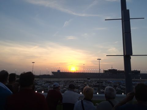 1994 Ford Bronco - A wide view of a race track and its surrounding parking lot as the sun sets.