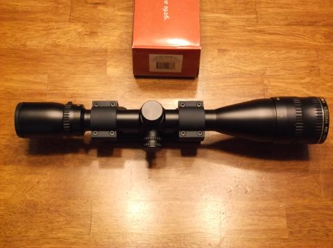 1995 Mercury Grand Marquis - A rifle scope and its original packaging are displayed on a wooden table.