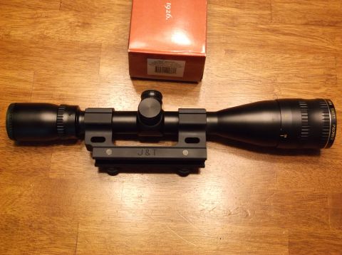 1995 Mercury Grand Marquis - A rifle scope with its mount and original box are displayed on a wooden table.