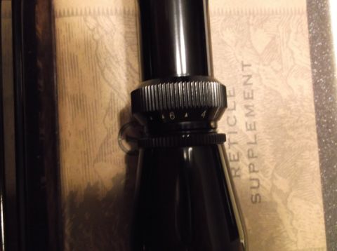 1995 Mercury Grand Marquis - Close-up of a rifle scope's magnification adjustment ring, with visible markings.