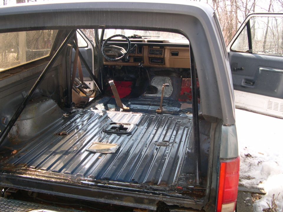 Interior of a stripped-down SUV, showing the empty cargo area and dashboard