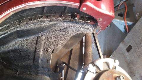 2000 Pontiac Grand Prix - Close-up of the wheel well and suspension components of a vehicle, with a jack stand in the background.