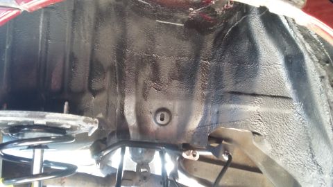2000 Pontiac Grand Prix - Underside view of a vehicle's wheel well, revealing black undercoating and suspension parts.