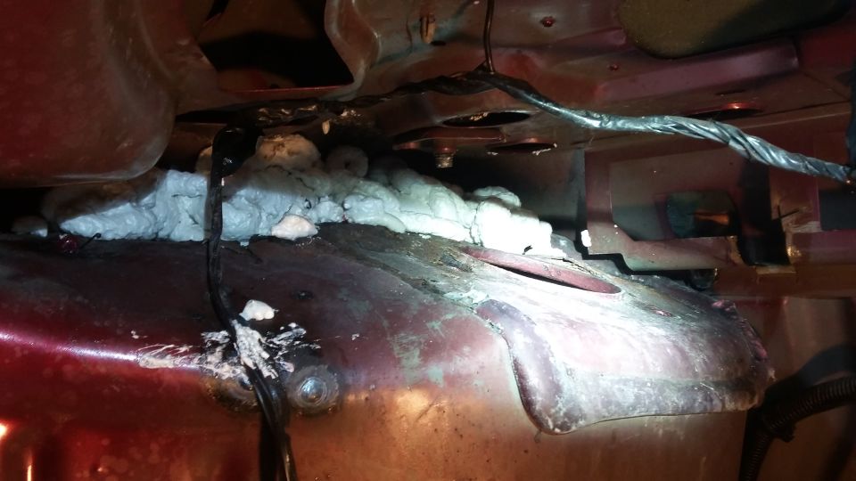 close-up of car underbody with expanding foam and wiring